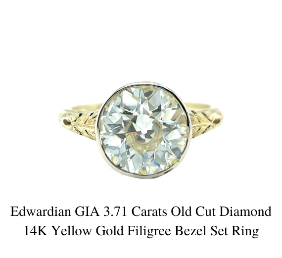 Close up of Edwardian 3.71 Carats Old Cut Diamond in a 14k yellow gold filigree bezel set ring on white background.