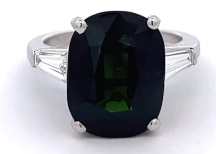 Mid century no heat green sapphire diamond ring accented by two tapered baguettes on a platinum setting