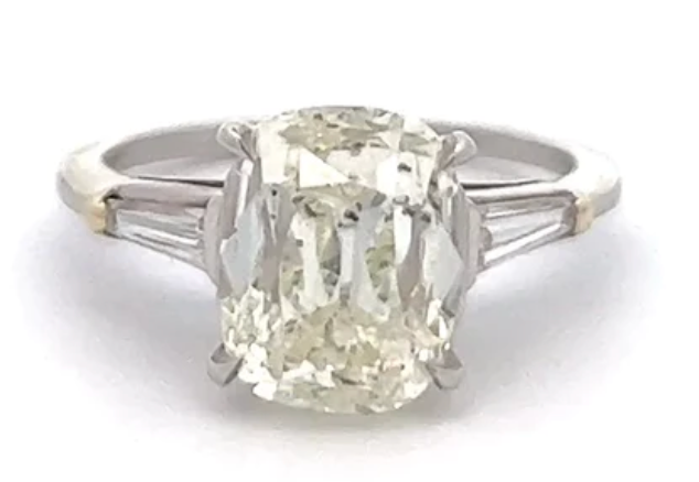 4 carat old mine cut diamond accompanied by two tapered baguettes 14 karat on a platinum setting