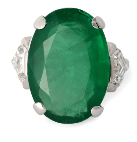 Mid century 13.93 carat zambian emerald cocktail ring accented by two shield cut diamonds on the side on a platinum setting