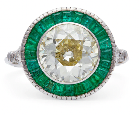 Art deco inspired 2.51 carat old mine european cut diamond accented by 25 calibre cut emeralds on a platinum setting