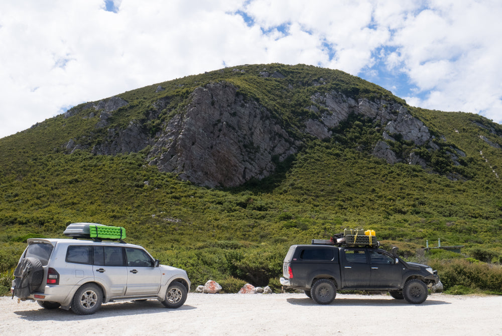 Two 4WDs in front of a mountain in Tasmania