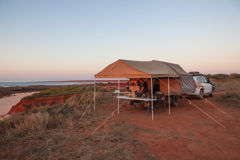Man Preparing A Meal Under Awning Of an Off Road Camper