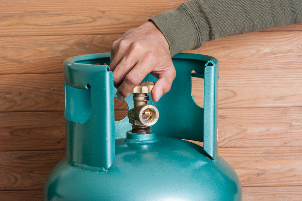 Man twisting the knob on a gas bottle