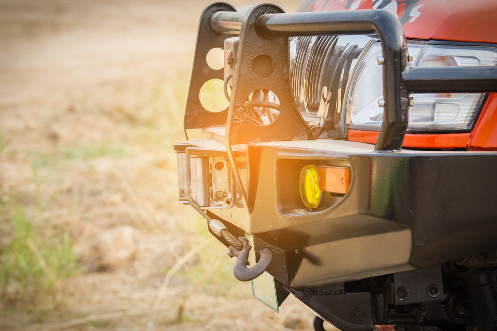 Close up side view of the front of a red 4WD with bullbar