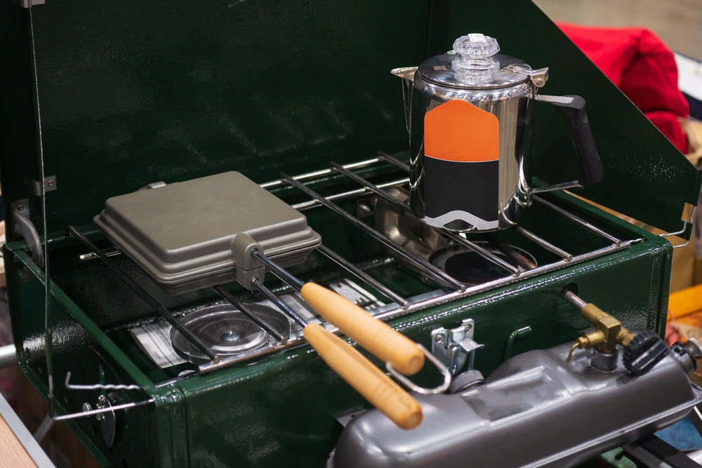 Camp kitchen equipment: Mocha pot, jaffle maker, portable gas burner.