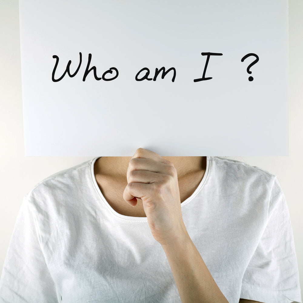 White sign over a face that reads "Who Am I?"
