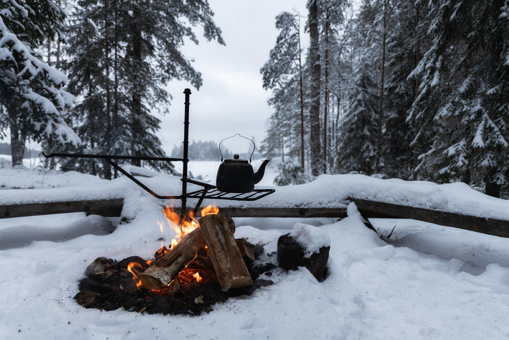 Camp kettle over a campfire in the snow