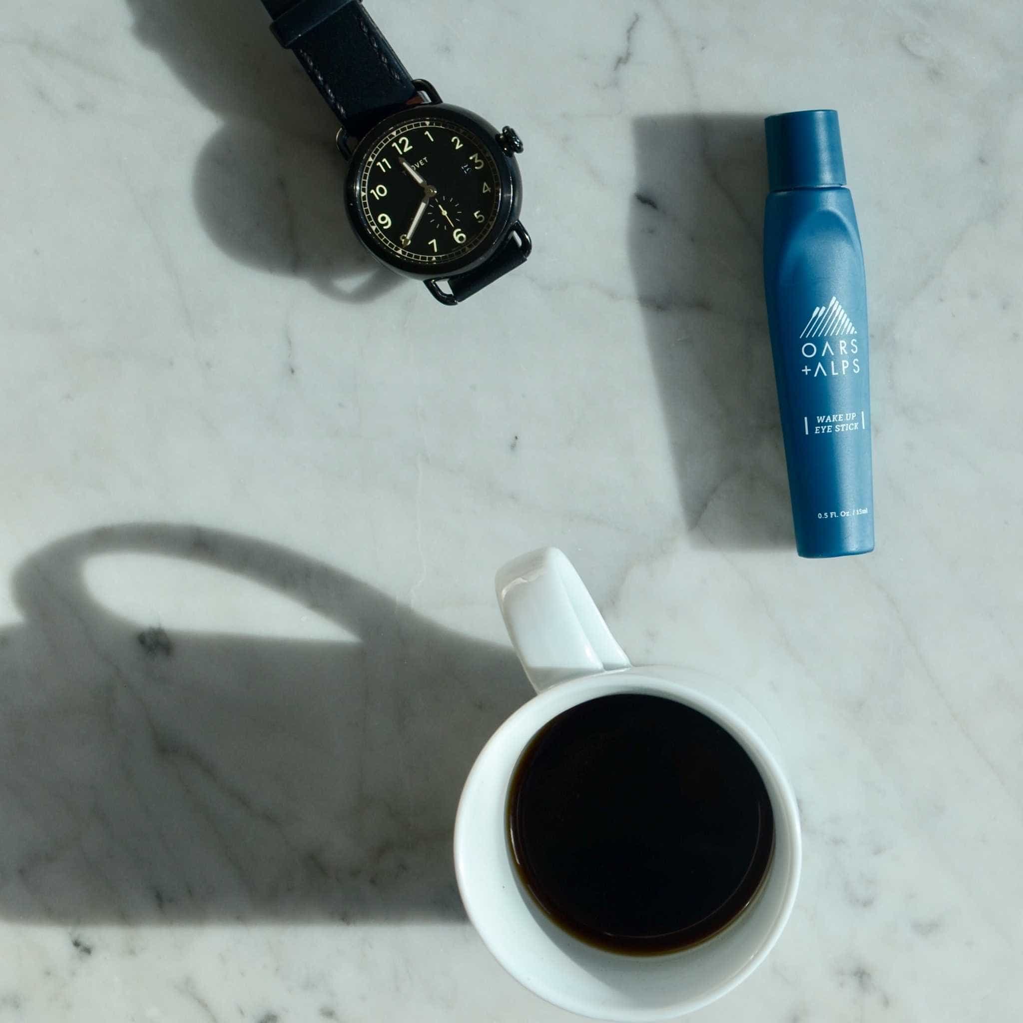 Undereye roller with caffeine and cup of coffee