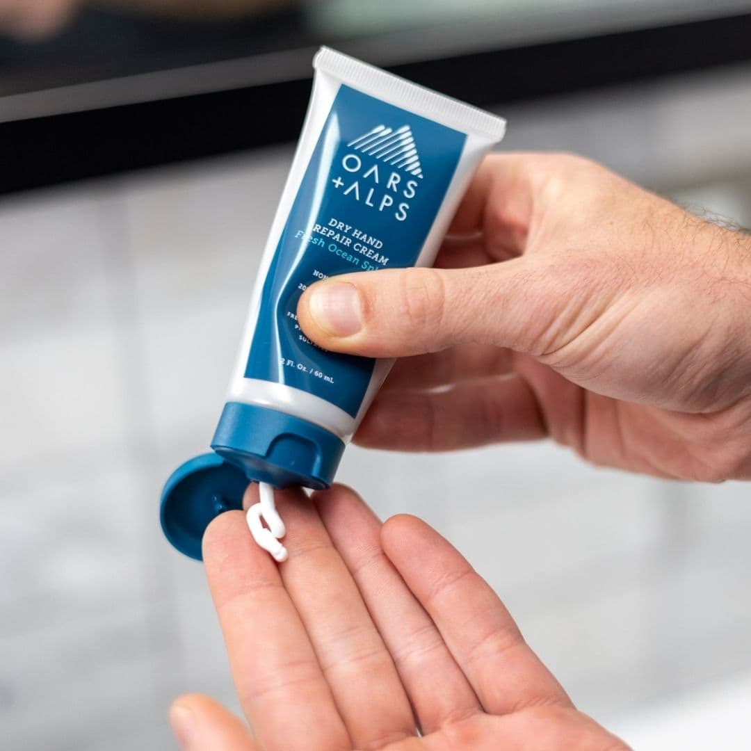 Man putting hand cream on dry hands