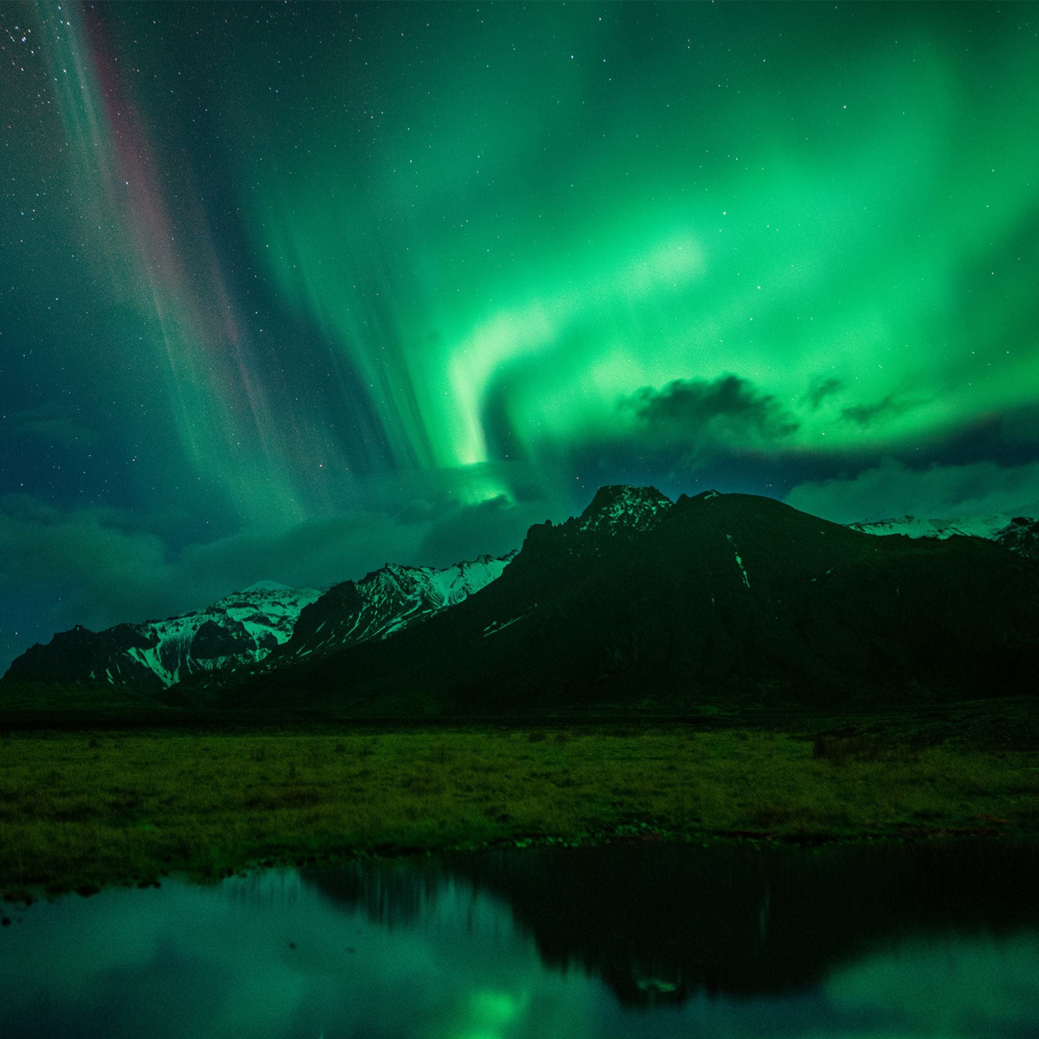 Vibrant green Northern lights over a mountain
