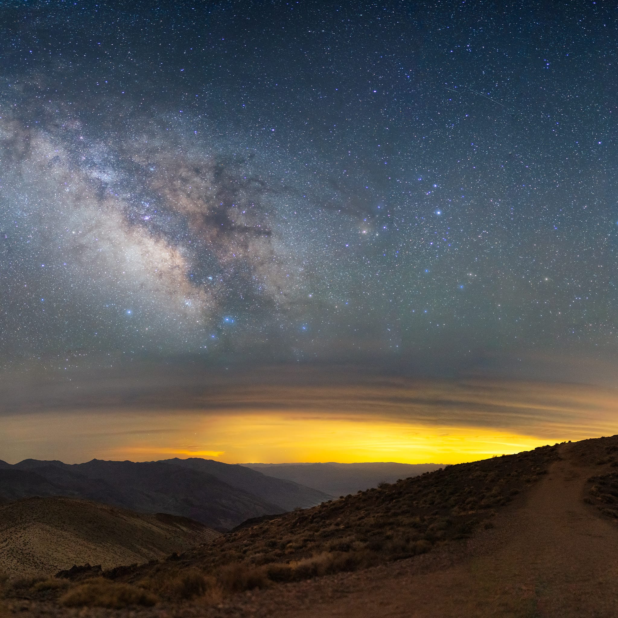 The Milky Way stretches across the sky as a silhouette stands out along Dante's View in Death Valley.