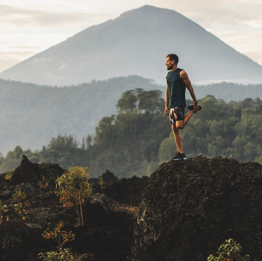 A man stretching while out on a hike