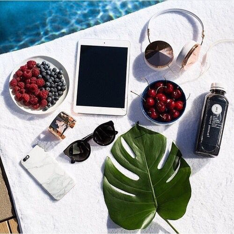 headphones and summer essentials flatlay poolside