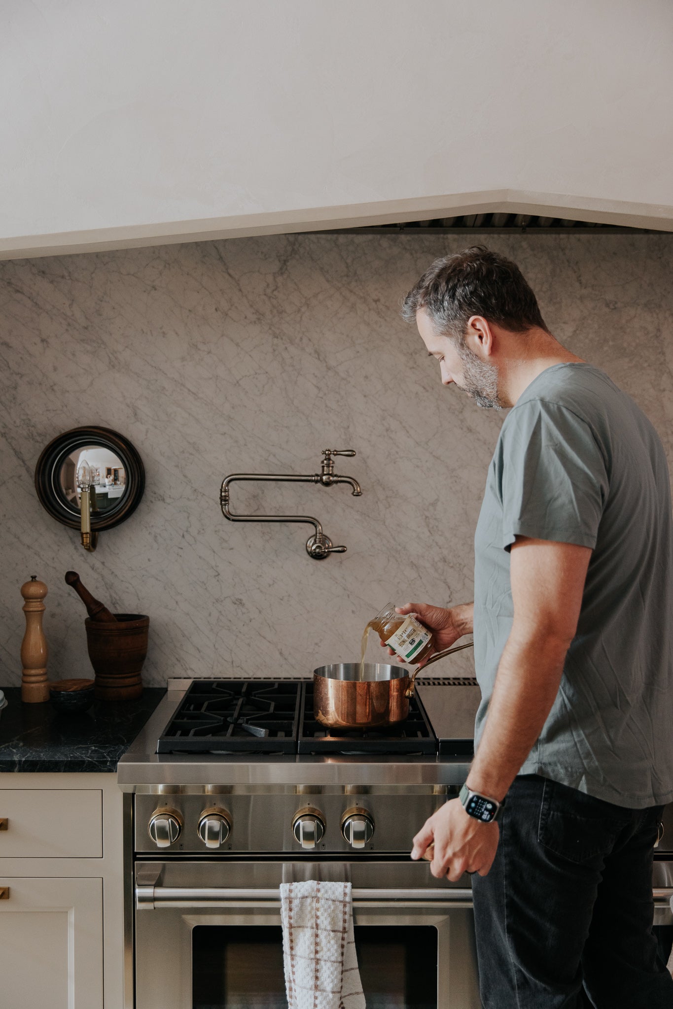 chris pouring epic bone broth in a cooking pan
