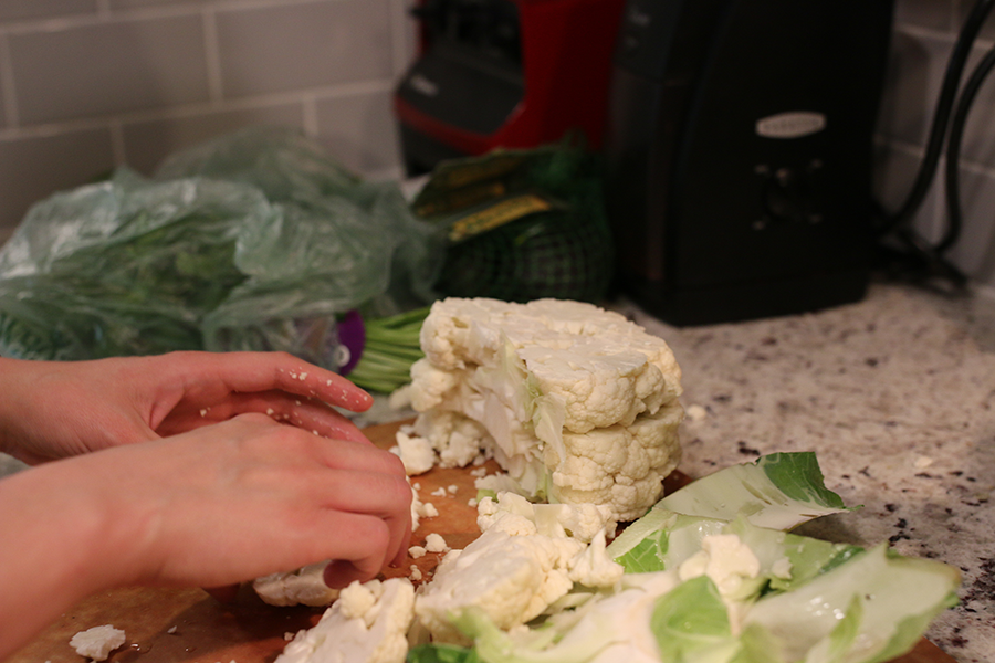 Cauliflower being chopped and pulled apart.