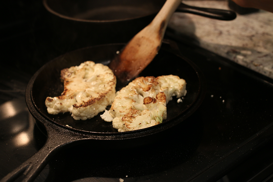 Cauliflower Steaks cooking in a skillet.