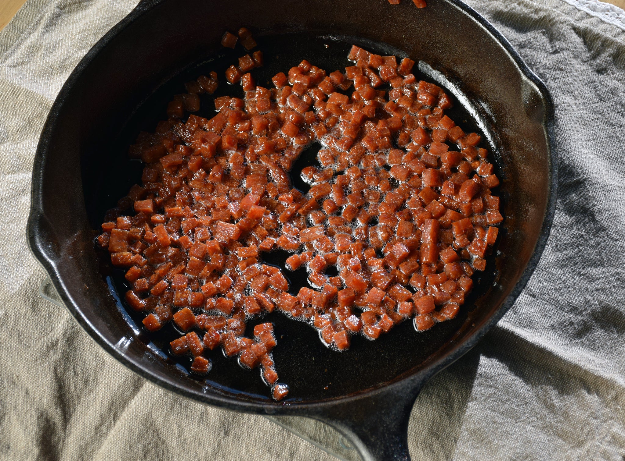 epic hickory smoked bacon bits being cooked in a pan