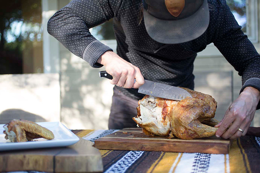 A fried turkey on a cutting board being carved up.