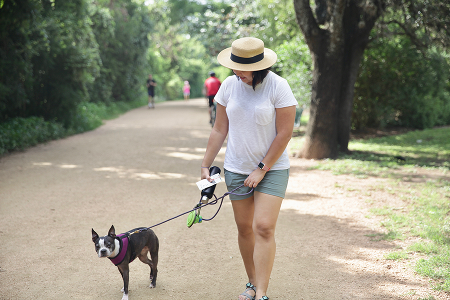 Woman walking with her dog on a trail.