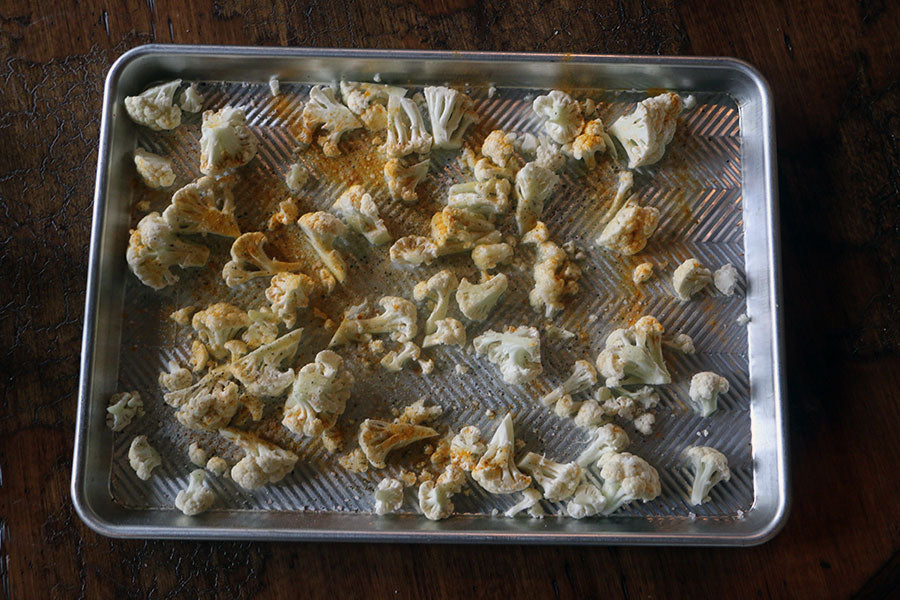 A pan of uncooked cauliflower florets tossed in Epic Beef Tallow.