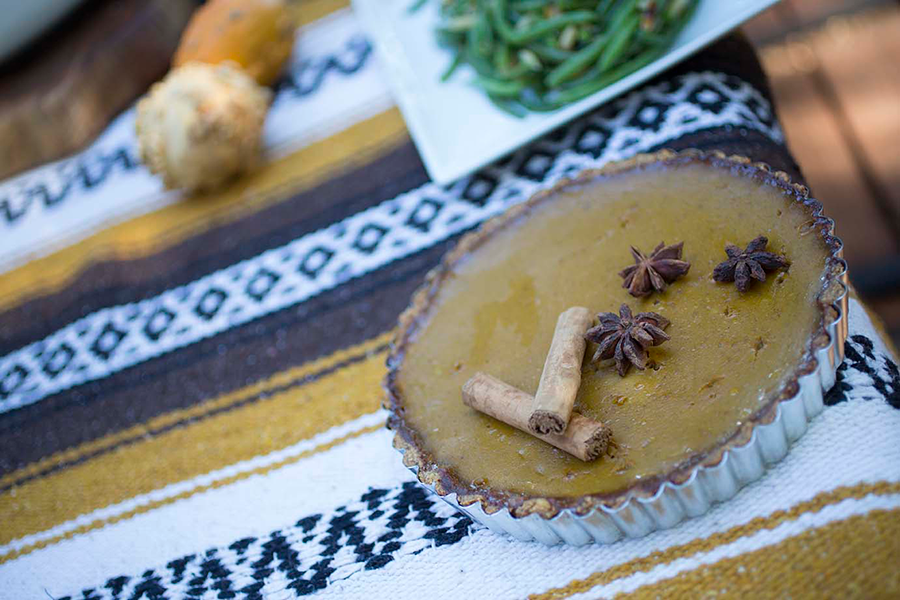 Epic Pork Crackling Pumpkin Pie on a table next to a plate of green beans.