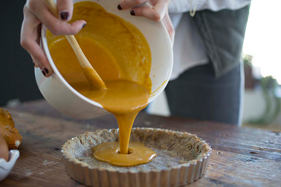 Pumpkin Pie mixture being poured into the pie crust.