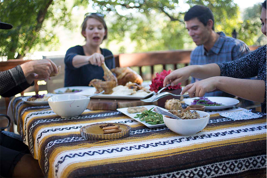 Group of people sitting at an outdoor table sharing a meal