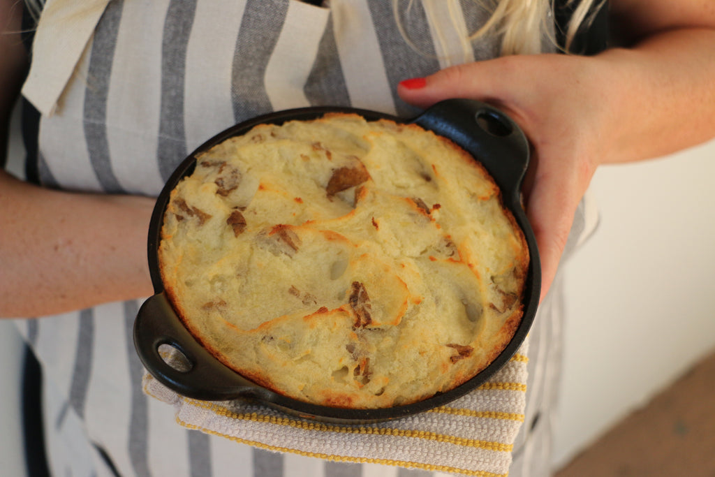 A close up of a woman holding a skillet shepherd's pie made with EPIC's Beef Tallow.