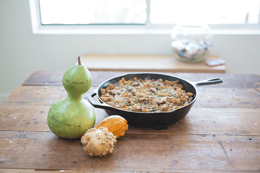 Skillet of stuffing laid out on a wooden table.