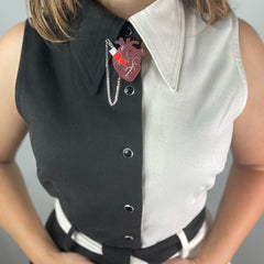 Woman in a black and white top wears and Vinca's anatomical heart bolo tie with chef's knife accent.