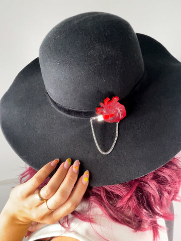 Anatomical heart pin on wide brimmed hat