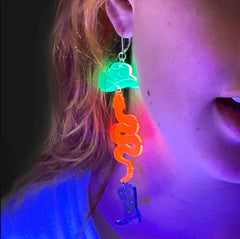 Neon Cowboy earrings glowing under black light.