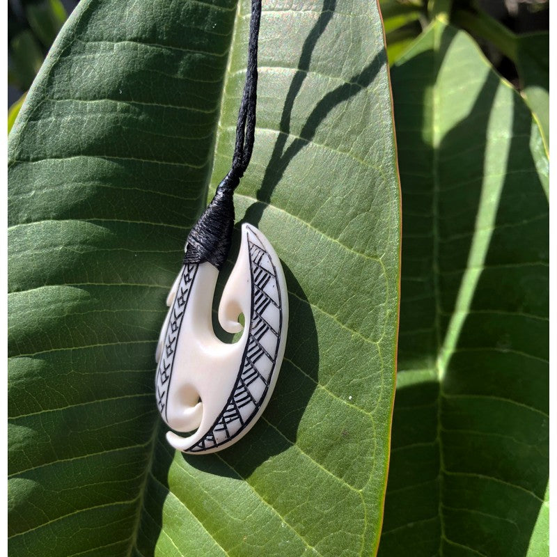 A beautiful Hawaiian Fish Hook necklace made by hand and features  engravings and abalone shells set into hook. Wood carved from Sonokeling  wood and has