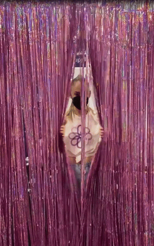 A gif of Catalina Bloch, PBSCO team member, opening and closing a purple sequin curtain.