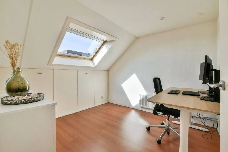 A compact home office with a desk and ergonomic chair, illustrating how to make a desk chair more comfortable for long working days.