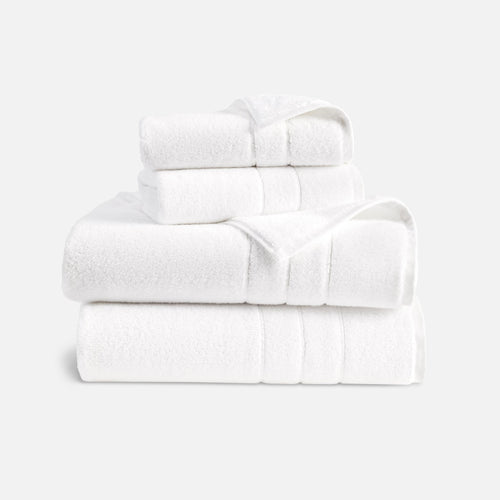 Premium Photo  Roll up of clean towels on white table with candle and  houseplant, copy space.