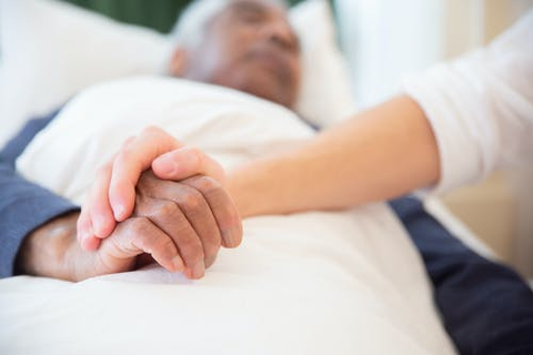 a person holding a patient’s hands