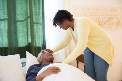 a woman with her hand on a patient’s forehead