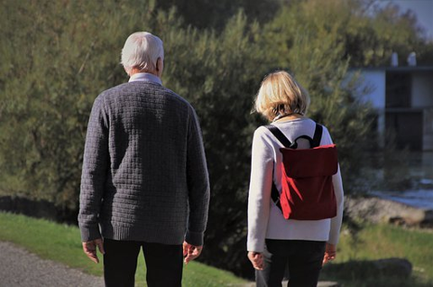 an older man walking with a young woman