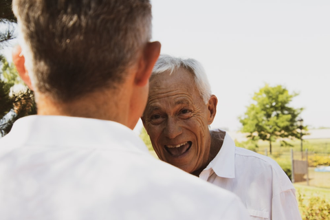 an elderly man smiling at the young attendant on-call 