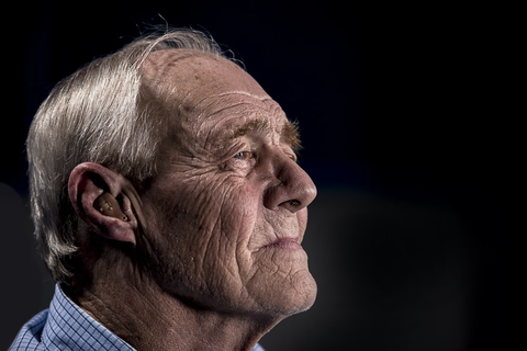 an elderly man looking thoughtfully into the distance 