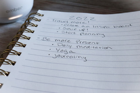 A list of things to do written in a notebook with a coffee mug in the background. 