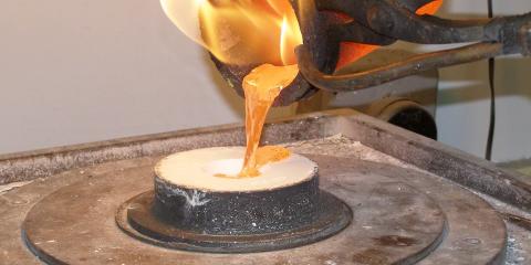 Molten gold being poured into a flask for casting.