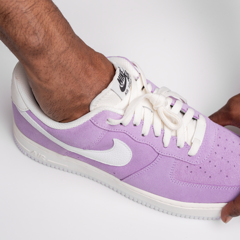 hand sliding into a purple shoe