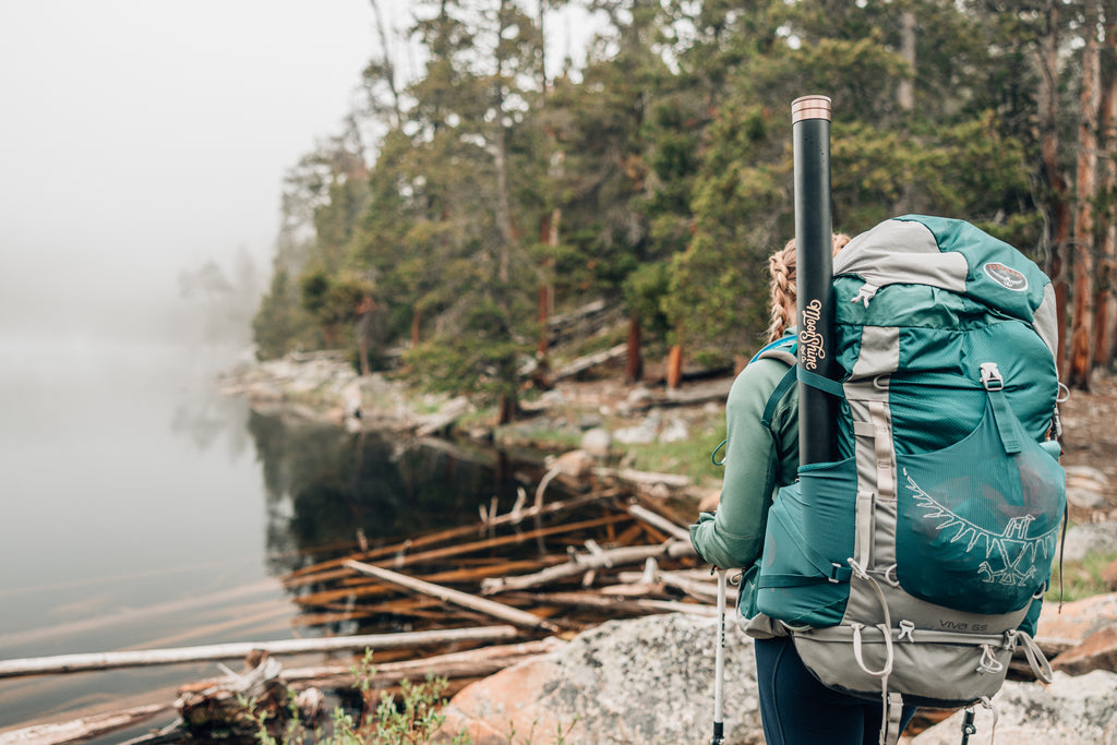 This image, from Moonshine Rods, shows a backpacker looking over an alpine lake.