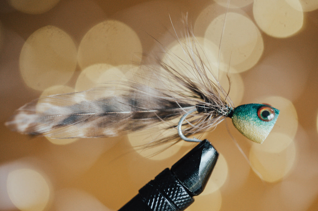 This photo, from Moonshine Rods, shows a bass popper fly in a fly-tying vise.