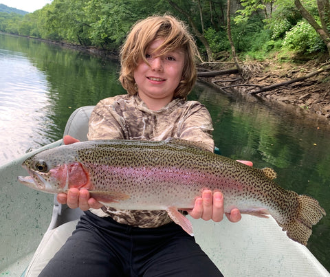 young boy catching a rainbow trout on a guided fly fishing trip