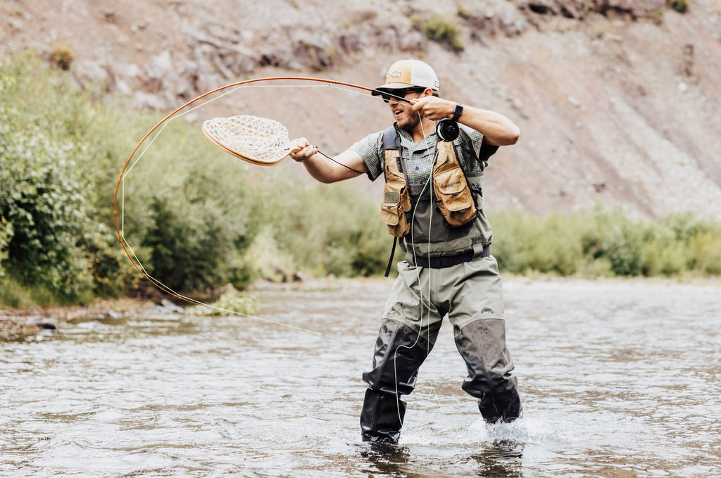 This image, from Moonshine Rods, shows an angler fighting a fish on a fiberglass fly rod.