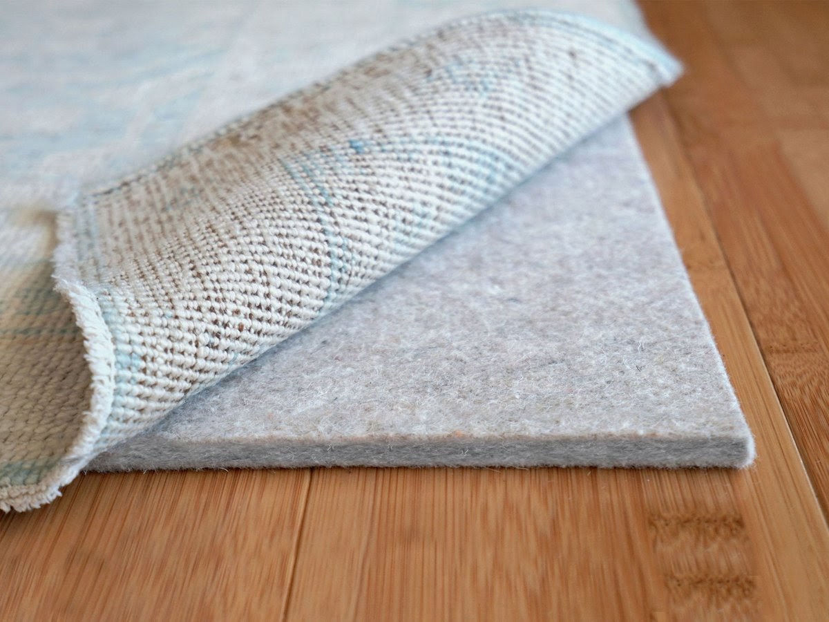 a cushioned rug pad acts as a barrier to protect a high traffic area rug
